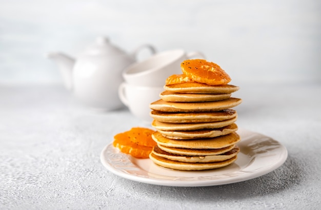 Nahaufnahme köstliche Pfannkuchen mit Mandarinen zum Frühstück auf hellem Hintergrund. Speicherplatz kopieren.