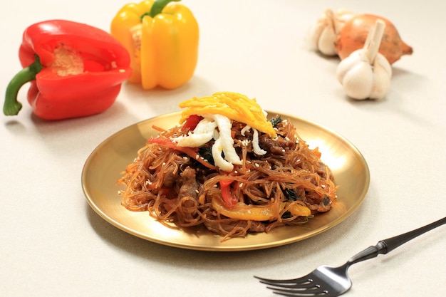 Nahaufnahme koreanische authentische Küche, Japchae oder Glasnudeln gebraten mit Gemüse in Goldplatte. Essen Sie täglich oder am Chuseok Day