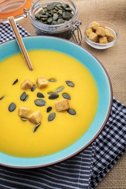 Nahaufnahme Kürbiscreme in der Schüssel. Mit Croutons und Kürbiskernen.