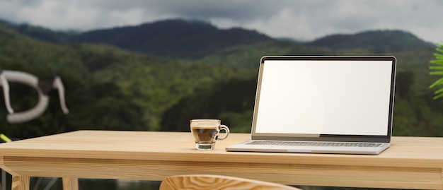 Nahaufnahme, leerer Raum auf Holzarbeitstisch mit Laptop-Modell des leeren Bildschirms und Kaffeetasse über Bergblick im Hintergrund. 3D-Rendering, 3D-Darstellung