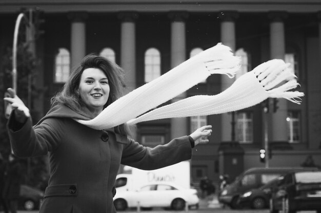 Nahaufnahme lustige Dame mit fließendem Schal auf der Straße monochromes Porträtbild