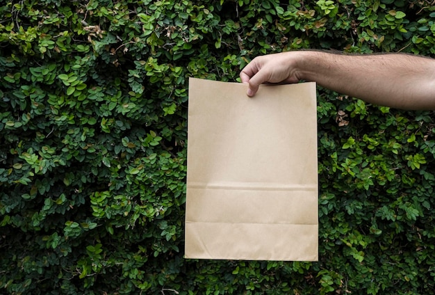 Nahaufnahme männlich hält in der Hand braune, klare, leere Papiertüte aus Kraftpapier zum Mitnehmen oder zur Lieferung