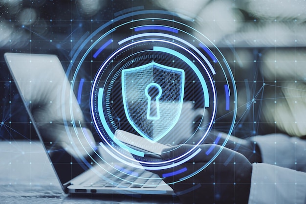 Nahaufnahme männlicher Hände mit Smartphone und Laptop auf dem Desktop mit kreativem, leuchtend blauem Schildhologramm auf verschwommenem Hintergrund Sichere Sicherheitsdatenbank und Webschutzkonzept Doppelbelichtung