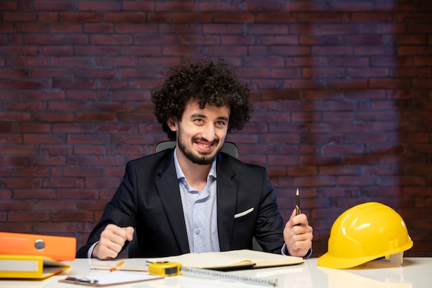 Nahaufnahme männlicher Ingenieur sitzt hinter seinem Arbeitsplatz in Anzug Agenda Job Auftragnehmer Plan Builder Corporate Business Work