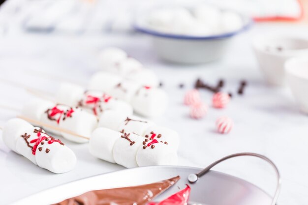 Nahaufnahme. Marshmallow-Schneemänner auf Stöcken für heißes Schokoladengetränk.