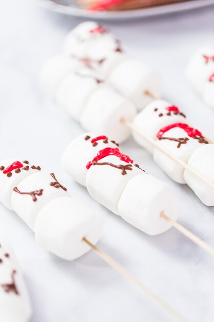 Nahaufnahme. Marshmallow-Schneemänner auf Stöcken für heißes Schokoladengetränk.