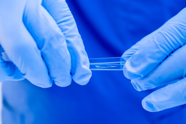 Nahaufnahme medizinischer Forscher lädt biologische Proben auf ein Glas für Mikroskop-DNA-Testfamilienbindungen