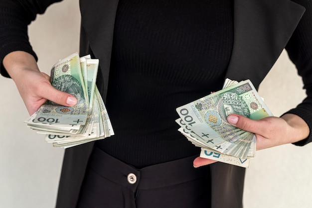 Nahaufnahme mehrerer Banknoten Stückelung von 100 Zloty Polnisches Geld Zloty hält einen Fächer in Form einer Frau in einem Anzug Das Konzept der Zloty in Frauenhänden
