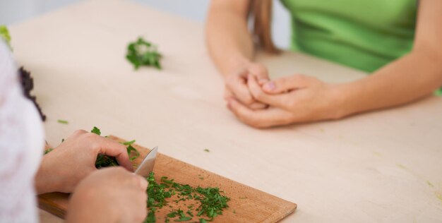 Nahaufnahme menschlicher Hände beim Kochen von Gemüsesalat in der Küche Gesundes Essen und vegetarisches Konzept