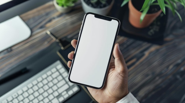 Nahaufnahme mit Hand im Telefon, die den weißen Bildschirm auf dem Schreibtisch zeigt