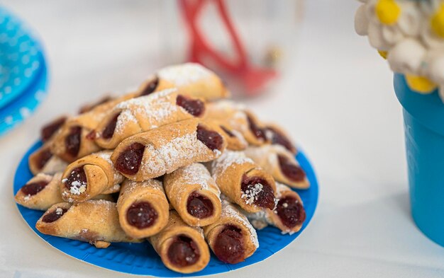 Nahaufnahme mit Mini-Croissants mit Marmelade auf dem Teller auf dem Tisch in einer Feier