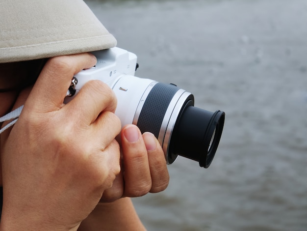 Foto nahaufnahme nicht erkennbare person, die fotos mit weißer spiegelloser kamera macht