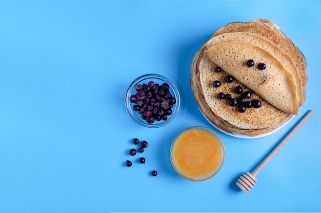 Nahaufnahme oben der russischen nationalen Küche und Dessertpfannkuchen mit Beeren und Honig. Traditionelles Gericht für Fastnacht. Selektiver Fokus. Speicherplatz kopieren.