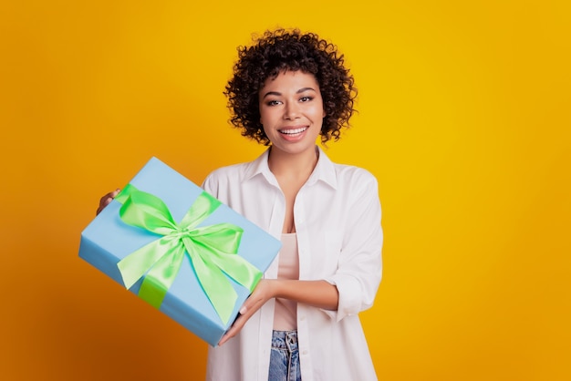 Nahaufnahme Porträt einer attraktiven jungen Afroamerikanerin, die Geschenkbox präsentiert