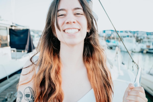 Nahaufnahme Porträt einer jungen Frau, die Sommerferien neben ihrer Yacht genießtLuxuriöse Yachtkreuzfahrt Seereisen mit einem LuxusbootJunge glückliche Frau auf dem Bootsdeck, das auf dem Meer segelt Yachting in GreeceSpain