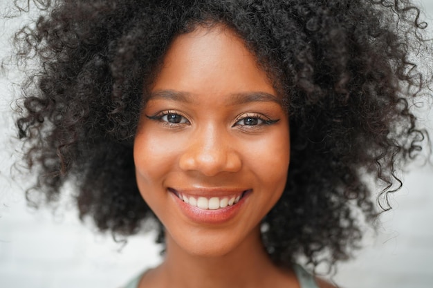 Nahaufnahme Porträt eines fröhlichen Afro-Mädchenlächelns mit Glück am Morgen