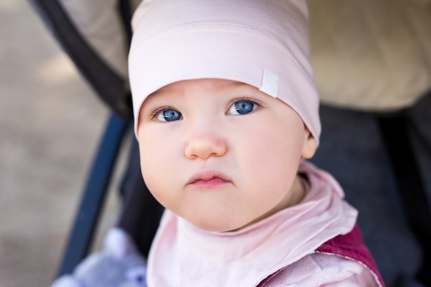 Nahaufnahme Porträt eines süßen kleinen Mädchens, das im Kinderwagen sitzt