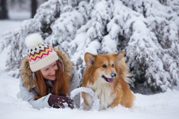 Nahaufnahme Porträt Hund Corgi flauschig und sein Besitzer spielen auf einem Winterspaziergang im Freien