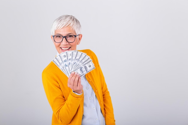 Nahaufnahme Porträt super glücklich aufgeregt erfolgreiche Seniorin Rentnerin mit Geld Dollarscheinen in der Hand Positive Emotion Gesichtsausdruck Gefühl Online-Shopping
