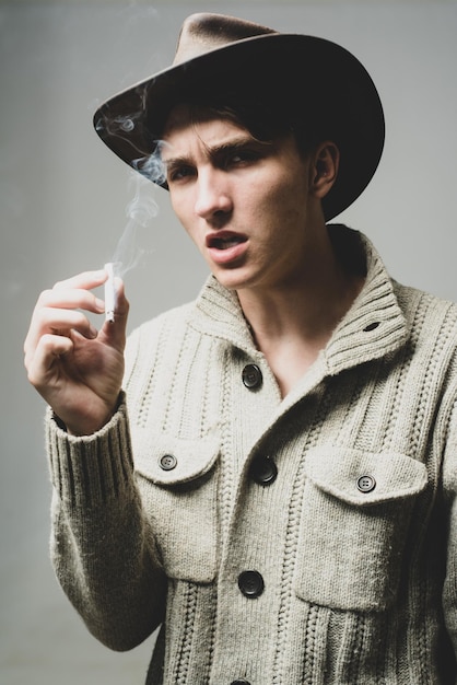 Foto nahaufnahme portrait von kerl in cowboyhut rauchen.