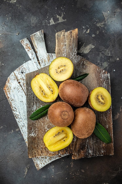 Nahaufnahme reifer goldener Kiwis. Lebensmittelhintergrund, vertikales Bild, Draufsicht, Platz für Text