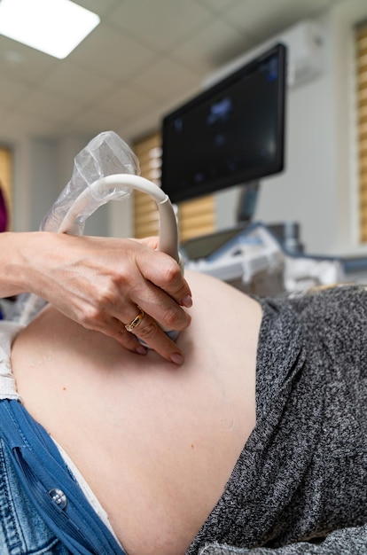 Nahaufnahme Ärzte bewegen den Schallkopf auf dem menschlichen Bauch Professionelle klinische Diagnostik und Behandlung