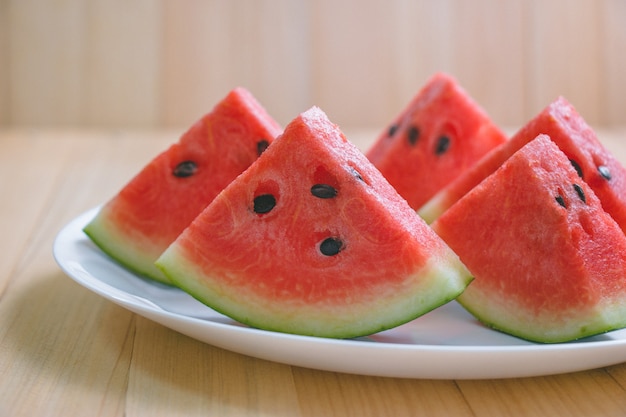 Foto nahaufnahme schneiden stücke der erfrischenden wassermelone auf einem hölzernen raum