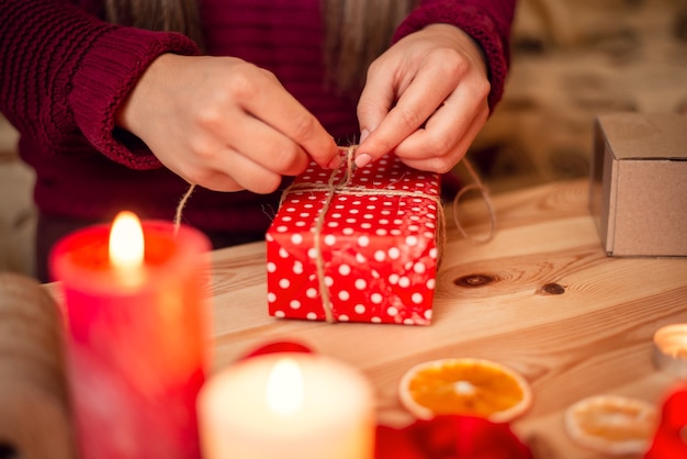 Nahaufnahme Schuss von Frauenhänden, einen Bogen mit Schnur auf einem Geschenk machend