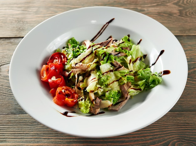 Nahaufnahme Schuss von gehacktem Salat gemischt mit geschnittenem Hühnerfleisch mit Sauce verziert