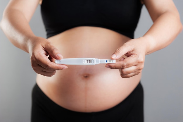 Nahaufnahme Schwangerschaftstest in der Hand der schwangeren Frau