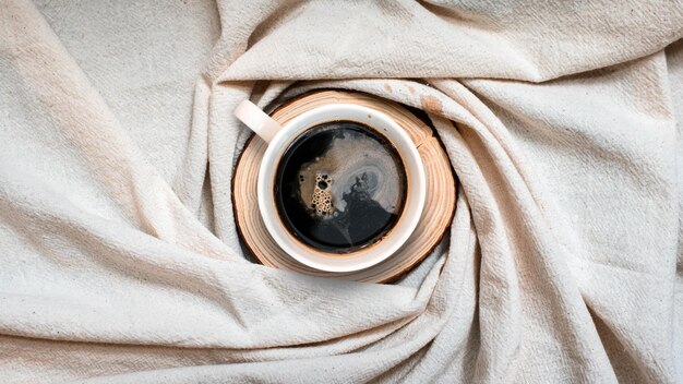 Nahaufnahme schwarzer Kaffeetasse auf Leinenstoff Top-View