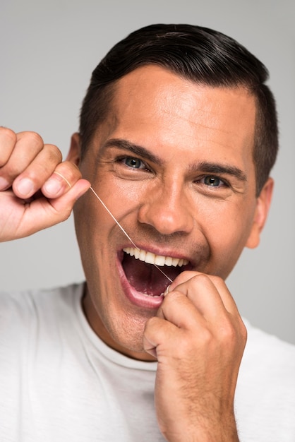 Foto nahaufnahme smiley-mann mit zahnseide