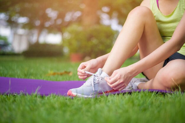 Nahaufnahme Sportfrau bindet Schuhe draußen