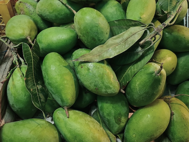 Nahaufnahme Stapel von frischen grünen Mangos mit Blättern