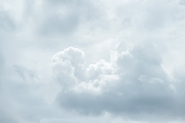 Nahaufnahme Tele, um weiße flauschige Baumwollwolken zu beruhigen, die in den Himmel fließen.