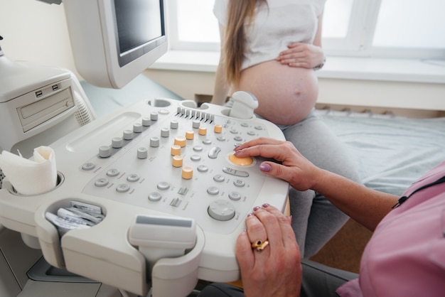 Nahaufnahme Ultraschallgerät während einer medizinischen Untersuchung einer schwangeren Frau. Medizinische Untersuchung