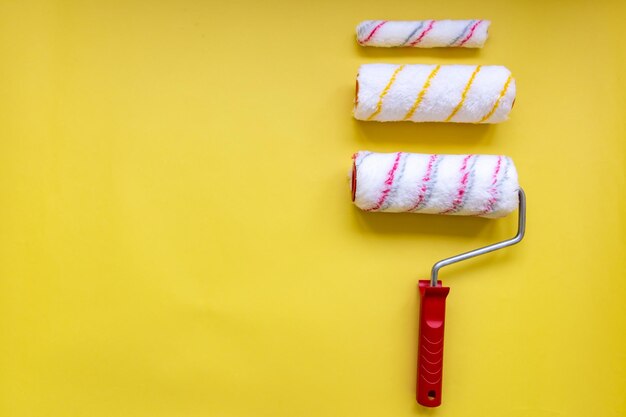 Foto nahaufnahme verschiedener farbrollen gegen eine gelbe wand