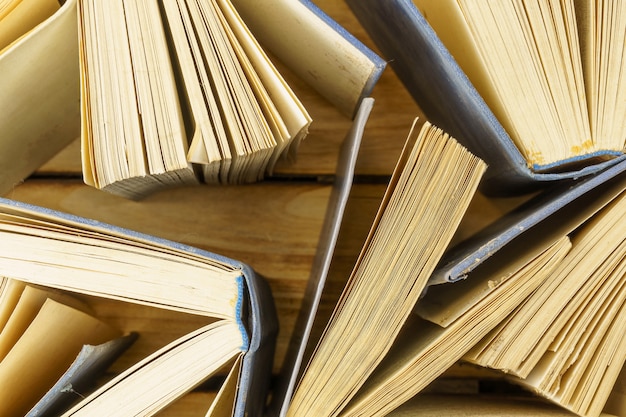 Nahaufnahme von alten gebundenen Büchern auf Holzoberfläche. Oberfläche von Büchern Draufsicht. Bücher öffnen, Seiten umblättern.