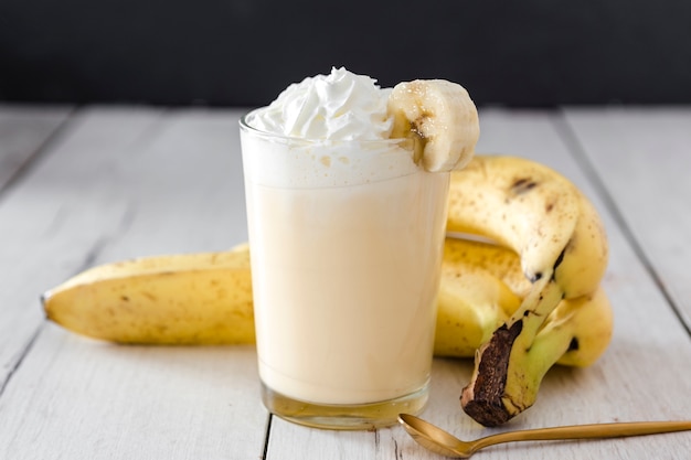 Nahaufnahme von Banane Smoothie mit goldenem Löffel