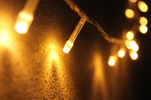 Nahaufnahme von beleuchteten Stringlichtern an der Wand in der Nacht