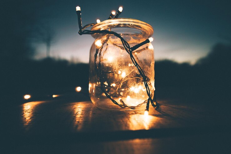Foto nahaufnahme von beleuchteten stringlichtern in einem glas nachts