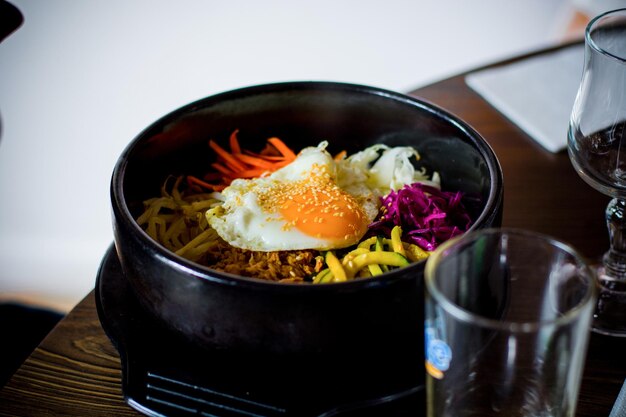 Foto nahaufnahme von bi bim bap, das in einem behälter auf dem tisch serviert wird