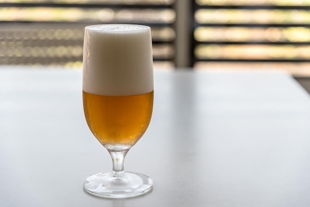 Nahaufnahme von Bier in einem Glas auf einem weißen Tisch