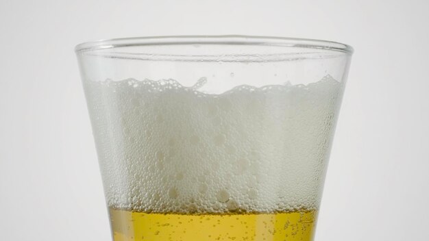 Foto nahaufnahme von bier in klarem glas auf weißem hintergrund aktionsbier in glas mit verschwindendem schaum auf