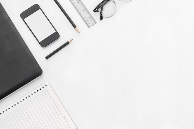 Nahaufnahme von Bleistiften und Mobiltelefonen auf dem Tisch