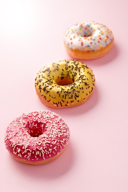 Nahaufnahme von bunten Donuts auf einem rosa Tisch