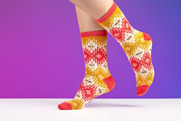Nahaufnahme von bunten weichen Socken auf weiblichen Beinen
