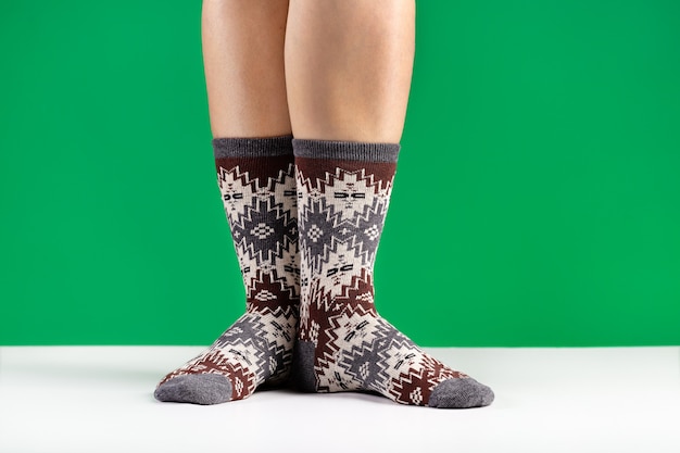 Nahaufnahme von bunten weichen Socken Das Konzept des Komforts und der Entspannung der weiblichen Füße grün