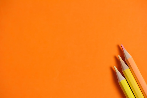 Foto nahaufnahme von buntstiften an einer orangefarbenen wand mit kopierraum