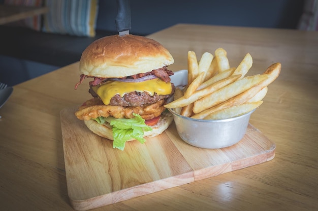 Nahaufnahme von Burger und Pommes Frites auf Holzplatte